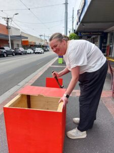 Hammering red Christmas box together for Christmas tree Glen Huntly Christmas celebrations