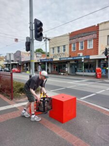Putting red boxes together for Christmas trees in glen huntly shops