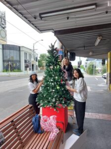 3 girls erecting Christmas trees in Glen Huntly